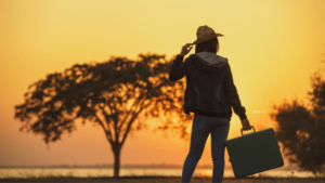 Frau in Freiheit auf Reisen mit Koffer